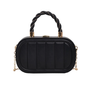 Detail of black quilted leather evening clutch with gold chain and twisted handle