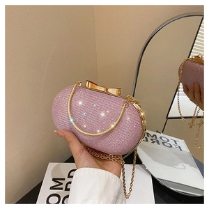 Détail de la pochette à paillettes roses avec fermoir nœud doré et chaîne