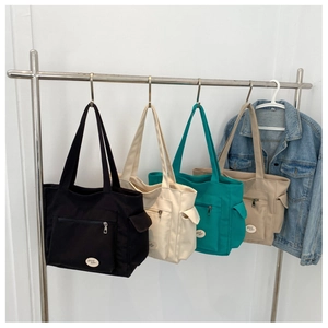 Detailed view of multi-color canvas tote bags with zipper pockets and lucky tags