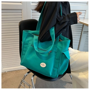 Lake green canvas tote bag with Good Luck label shown as a crossbody shoulder bag