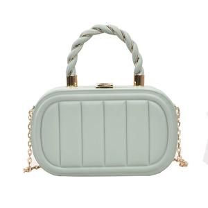 Detail of mint green box bag with vertical textures, twisted handle and gold chain