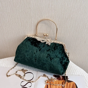 Elegant emerald green velvet evening bag with diamond butterfly clasp and gold handles