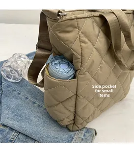 Close-up of the side pocket on khaki quilted tote bag holding a blue folding umbrella