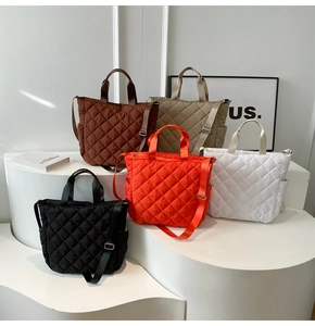 Quilted tote bags in black, coffee, beige, orange, and white shown on minimalist stands