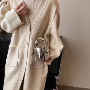 Close-up of silver mirror bucket bag featuring unique heart-shaped cutout handle and chain