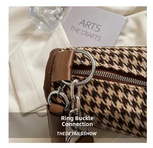 Detail of silver oversized ring buckle and herringbone weave on a retro shoulder bag