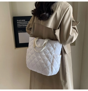 Detail of white quilted rhombus tote bag showing nylon texture and side pocket