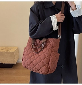 Detail of dark brown quilted tote bag with diamond stitching and convenient side pocket