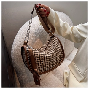 Detail of vintage houndstooth shoulder bag with leather trim and chain canvas strap