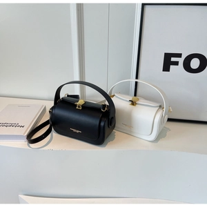 Détail de sacs bandoulière en cuir noir et blanc avec fermoirs coquille dorés