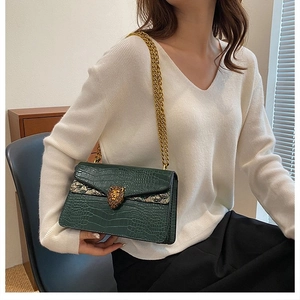 Elegant dark green crocodile pattern crossbody bag with a gold lion head buckle and chain