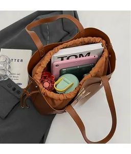 Macro view of brown tote bag interior showing large capacity for tablet and magazines
