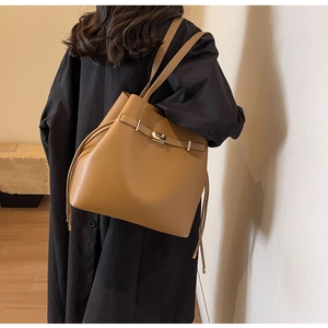 Detail of the golden metal twist lock and drawstring on the brown retro tote bag