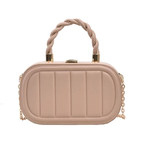 Detail of nude pink quilted crossbody bag featuring spiral metal handle and gold lock