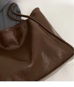 Nahaufnahme der dunkelbraunen Ledertasche mit feiner Lychee-Textur und Kantenverarbeitung