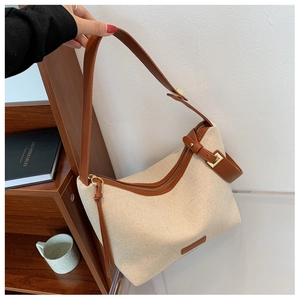 Detail von beige Leinwand und braunem Leder an einer minimalistischen Schultertasche