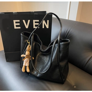 Detailaufnahme einer schwarzen Shopper-Tasche mit süßem braunem Plüsch-Hasenanhänger