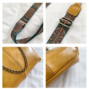 Detail of bohemian yellow crossbody bag showing vintage hardware and ethnic woven strap