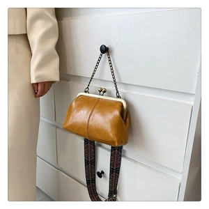 Detail of vintage frame bag with wide ethnic pattern strap and polished mustard leather