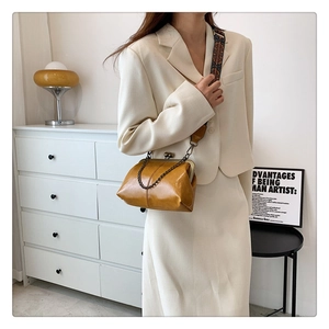Detail of ginger PU leather crossbody bag with metal clasp and bohemian wide strap