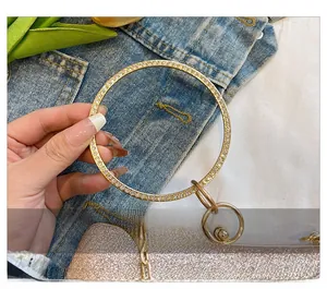 Détail du sac de soirée pailleté champagne avec poignée en métal ornée de strass