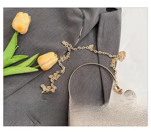 Macro detail of sparkly evening bag with gold twist chain and round metal handle ring