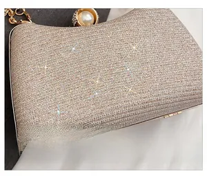 Macro shot of champagne sequin evening bag with large pearl and rhinestone clasp