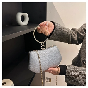 Détail de la pochette à paillettes argentées avec poignée ronde dorée et chaîne