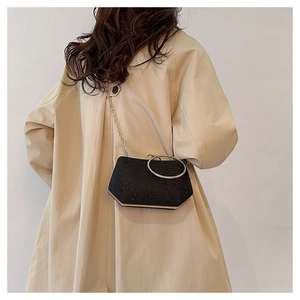Détail du sac de soirée noir pailleté avec poignée anneau doré et bandoulière chaîne