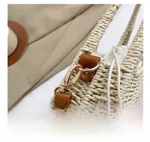 Macro shot of gold-tone hardware and straw woven texture on a vintage crossbody bag