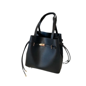 Minimalist black faux leather tote bag with drawstring details and gold hardware finish