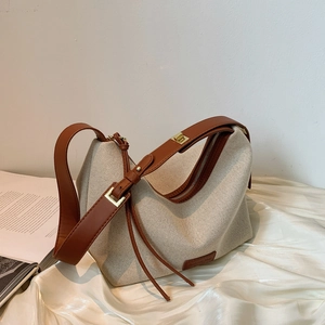 Minimalistische Hobo-Tasche aus beigem Canvas mit braunem Lederbesatz und Schultergurt