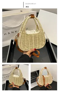 Detail of off-white straw woven handbag with brown leather straps and drawstring closure
