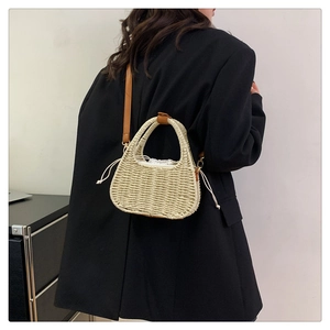Detail of hand-woven straw bag with leather strap and secure drawstring inner liner