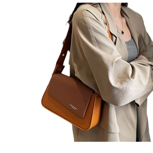 Retro brown leather and textured fabric crossbody bag worn with a khaki trench coat
