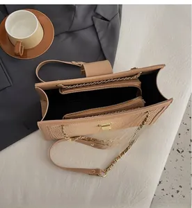 Innenansicht der beige gewebten Handtasche mit Reißverschlussfach und Metallkettenriemen