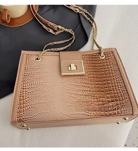 Detail der khakifarbenen Schultertasche mit Krokodilmuster, Goldschloss und Kettenriemen