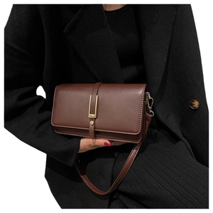 Borsa a tracolla vintage marrone scuro con dettagli dorati tenuta da una modella