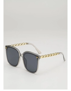 Détail de lunettes de soleil carrées avec monture grise et branches en chaîne dorée