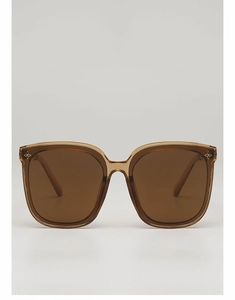 Détail de lunettes de soleil carrées avec rivets étoile dorés et monture translucide