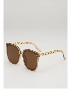 Détail de lunettes de soleil carrées avec branches en chaîne dorée et rivets étoiles
