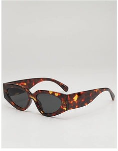 Détail de lunettes de soleil œil-de-chat rétro avec monture léopard et branches larges