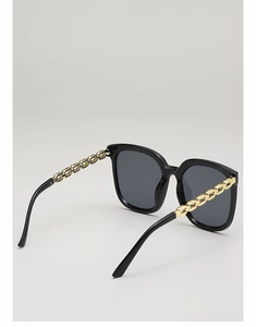 Détail de lunettes de soleil carrées noires avec branches en chaîne métal doré