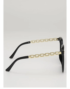 Détail de lunettes de soleil carrées avec monture noire et branches en chaîne dorée