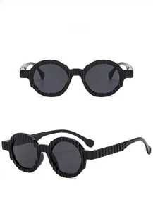 Detail of black round sunglasses with unique sawtooth textured frames and gray lenses