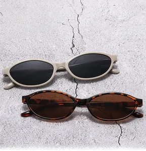 Detail of vintage oval sunglasses in cream white and tortoiseshell frames on a stone texture