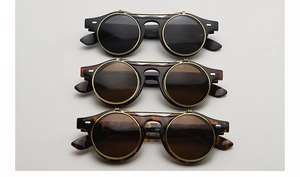 Détail de lunettes de soleil rondes relevables en noir, marron et monture en écaille