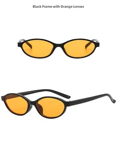 Detail view of oval retro sunglasses with black frames and trendy orange lenses