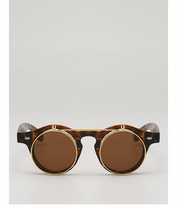 Détail de lunettes de soleil rondes à clapet avec monture écaille et charnière dorée