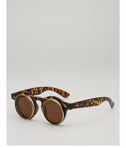 Détail de lunettes de soleil rondes vintage avec verres relevables et monture écaille